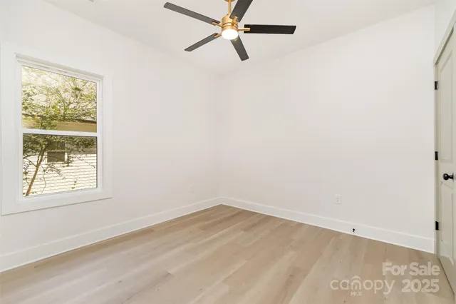 an empty room with a window and a fan