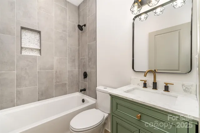 a bathroom with a toilet a sink a tub and a mirror