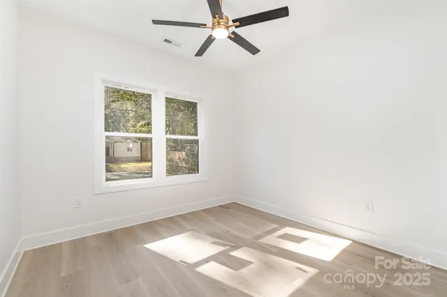 an empty room with a window and a fan