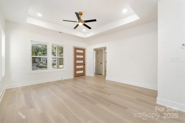 a view of empty room with windows and ceiling fan