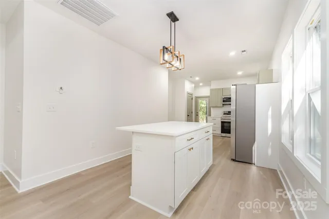 a kitchen with a refrigerator a sink and a window