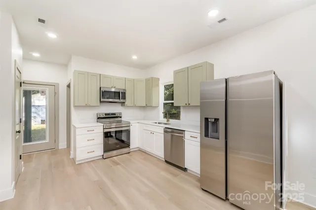 a kitchen with stainless steel appliances granite countertop a refrigerator and a stove top oven