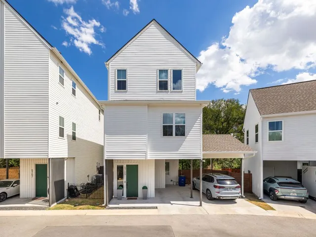 a view of a house with a barbeque and large trees