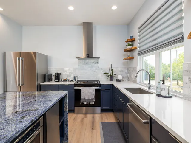 a kitchen with stainless steel appliances granite countertop a sink stove and refrigerator