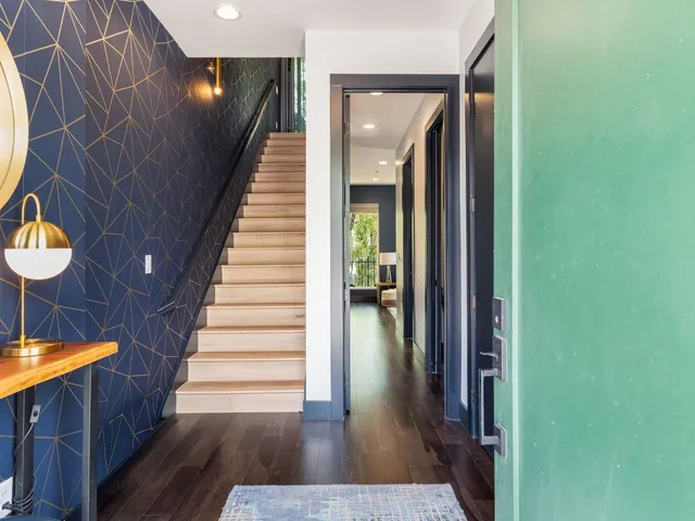 a view of a hallway with wooden floor and staircase