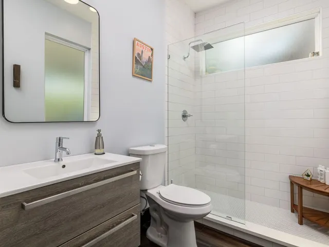 a bathroom with a sink mirror vanity and toilet