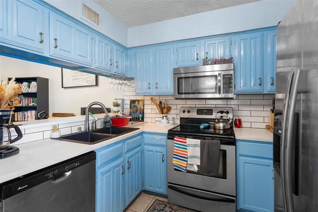 a kitchen with stainless steel appliances a stove sink microwave and cabinets