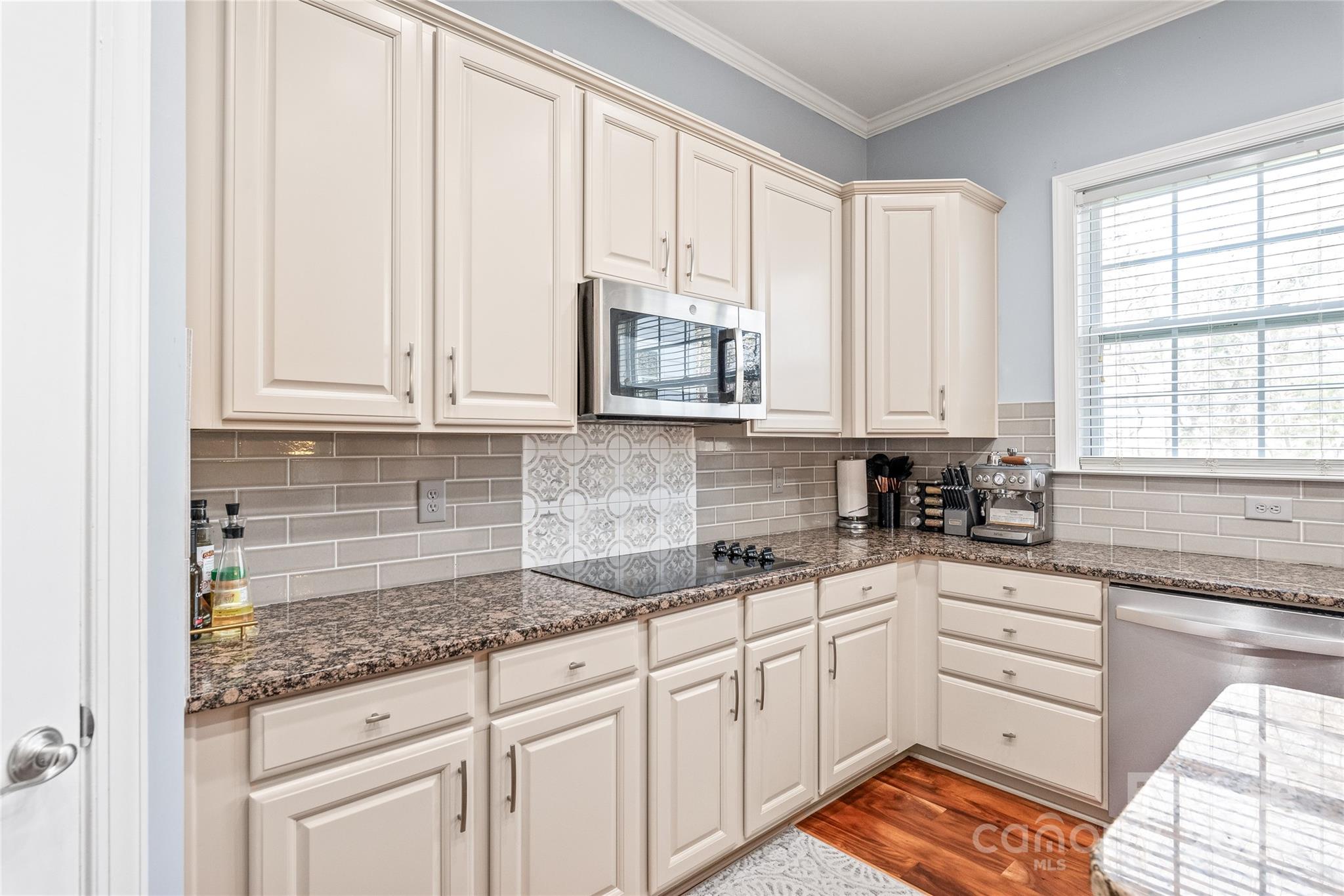 8504 Soaring Eagle Lane Waxhaw, NC 28173 - Photo 17 of 48 a kitchen with granite countertop white cabinets and window