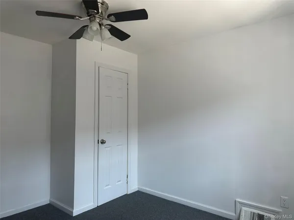an empty room with a fan and a ceiling fan