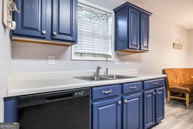 a kitchen with a sink cabinets and wooden floor
