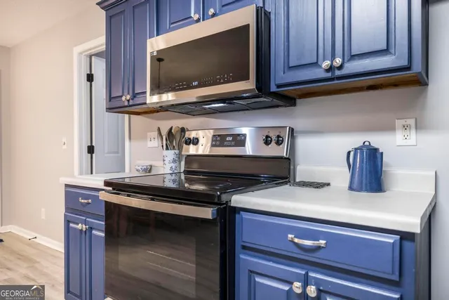 a kitchen with stainless steel appliances wooden cabinets and a stove top oven