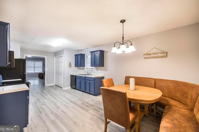 a dining room with furniture a chandelier and wooden floor