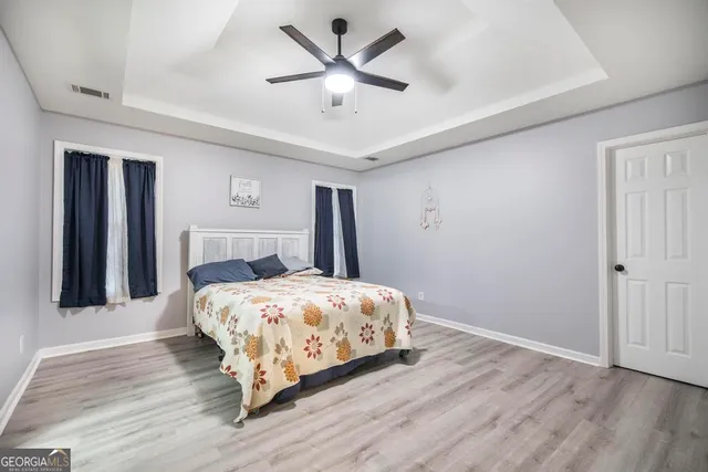 a bedroom with a bed and a ceiling fan