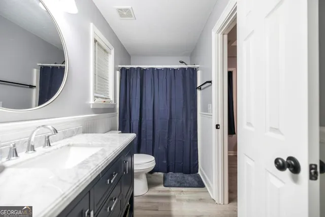 a bathroom with a granite countertop sink toilet and shower