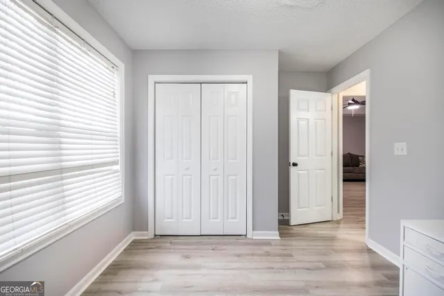 an empty room with wooden floor and windows