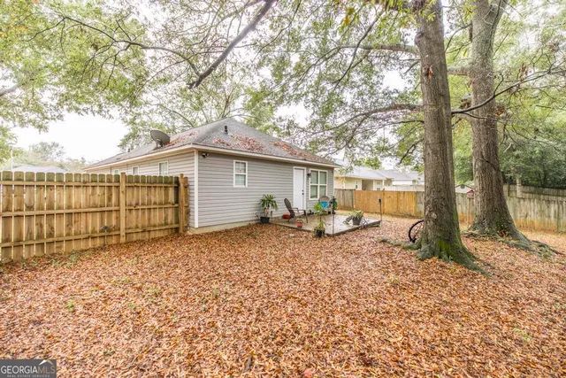 a view of a house with backyard and a tree