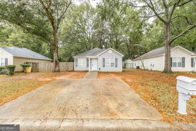 a front view of a house with a yard and trees