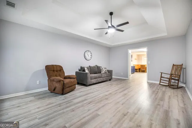 a living room with furniture and a wooden floor