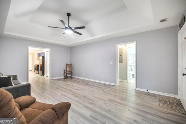 a living room with furniture and a ceiling fan