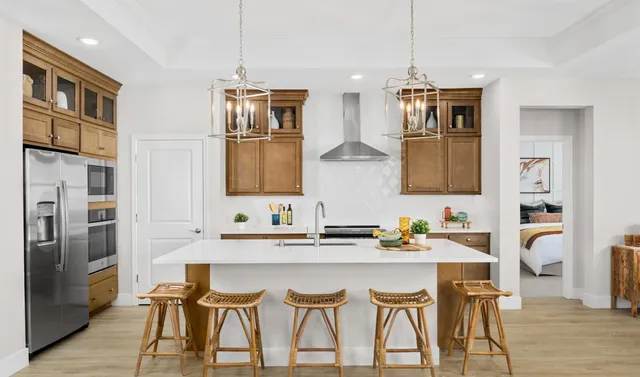 a dining room with stainless steel appliances kitchen island granite countertop a dining table chairs and a refrigerator