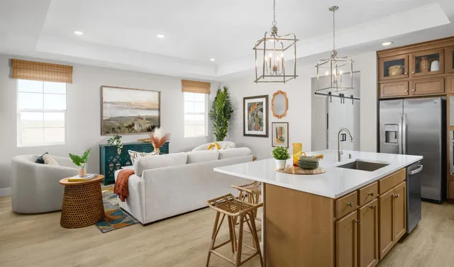 a very nice looking dining room with kitchen island furniture a large window and a chandelier