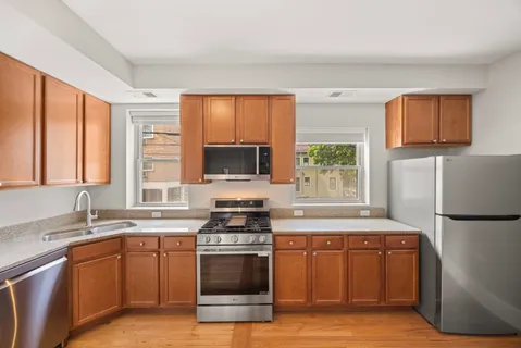 a kitchen with stainless steel appliances granite countertop a stove a sink and a refrigerator