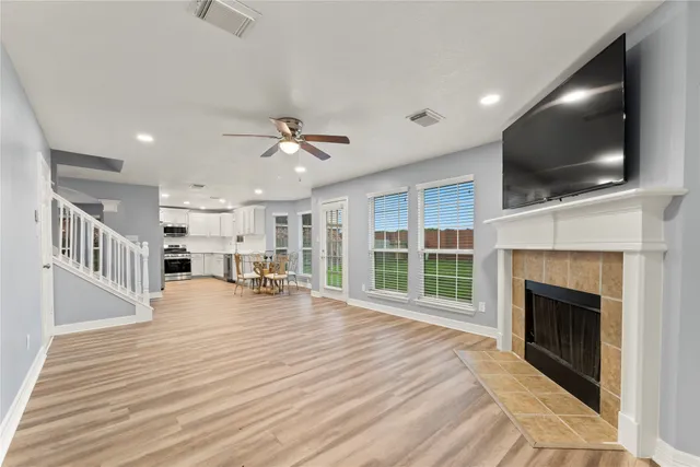 a view of a livingroom with wooden floor and a fireplace