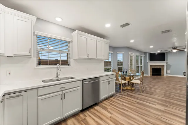 a kitchen with a sink white cabinets and white appliances