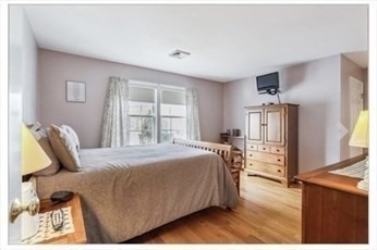 65 Camden Street, Unit 1 Lynn, MA 01905 - Photo 11 of 14 a bedroom with a bed wooden floor and window