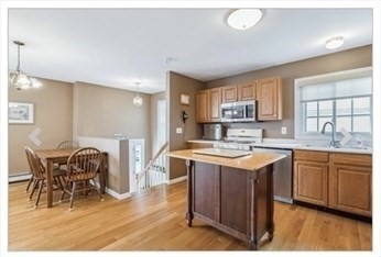 65 Camden Street, Unit 1 Lynn, MA 01905 - Photo 2 of 14 a kitchen with stainless steel appliances granite countertop a stove top oven a sink dishwasher and white cabinets with wooden floor