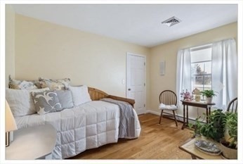 65 Camden Street, Unit 1 Lynn, MA 01905 - Photo 8 of 14 a bedroom with bed and a potted plant