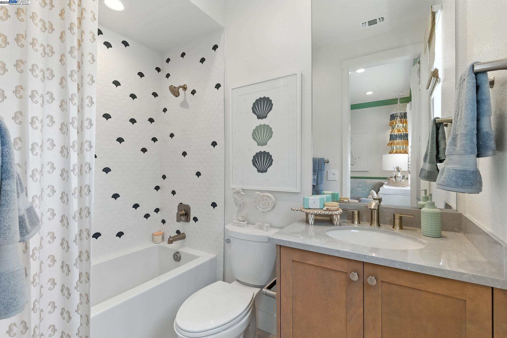 1937 Grand Street Alameda, CA 94501 - Photo 20 of 29 a bathroom with a granite countertop sink a toilet a mirror a vanity and bathtub