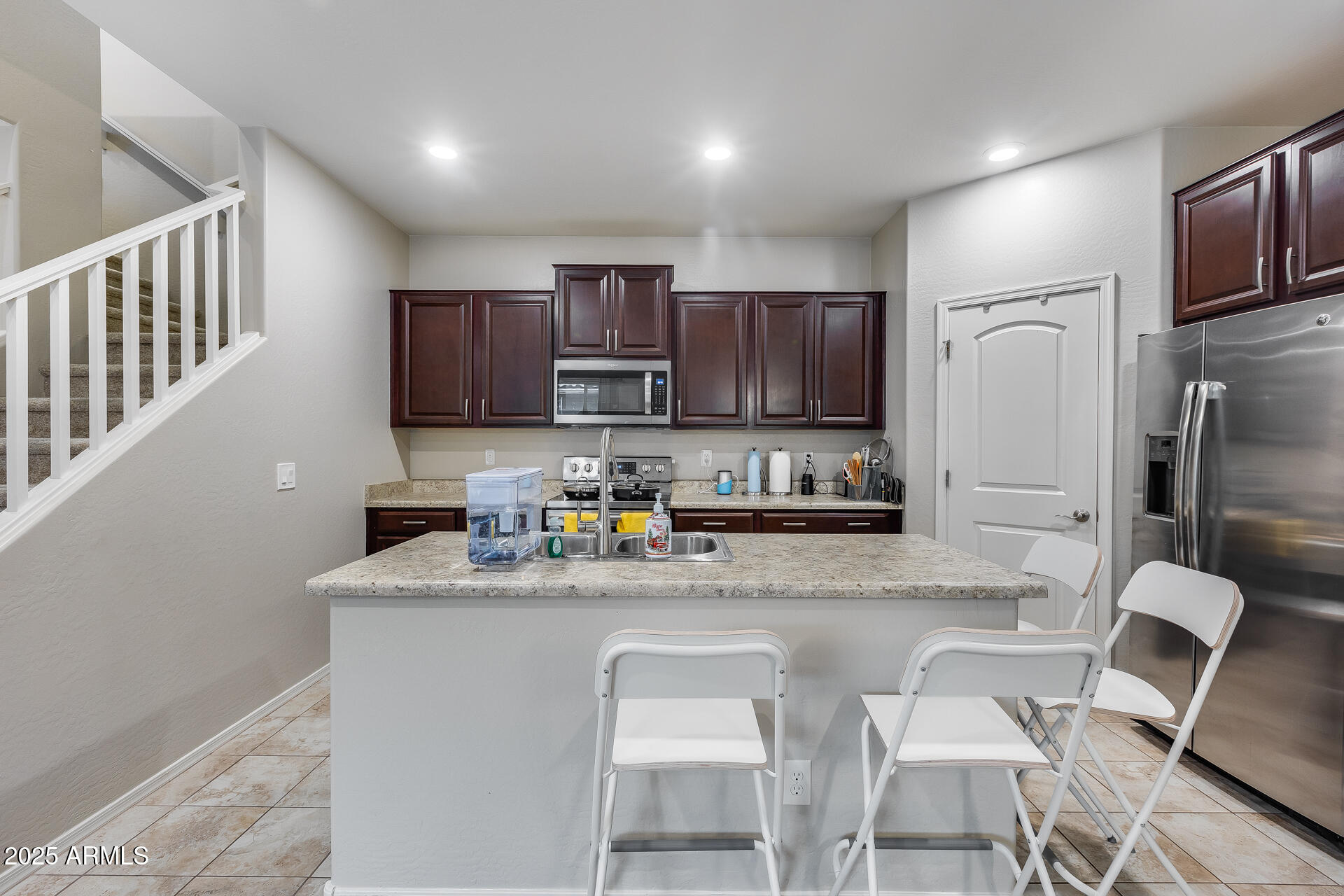 6853 East Posada Circle Mesa, AZ 85212 - Photo 15 of 45 a kitchen with stainless steel appliances granite countertop a sink refrigerator and cabinets