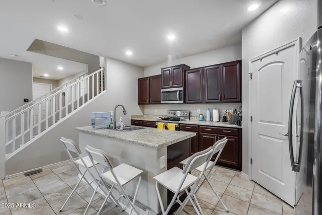 a kitchen with stainless steel appliances granite countertop a sink refrigerator and cabinets