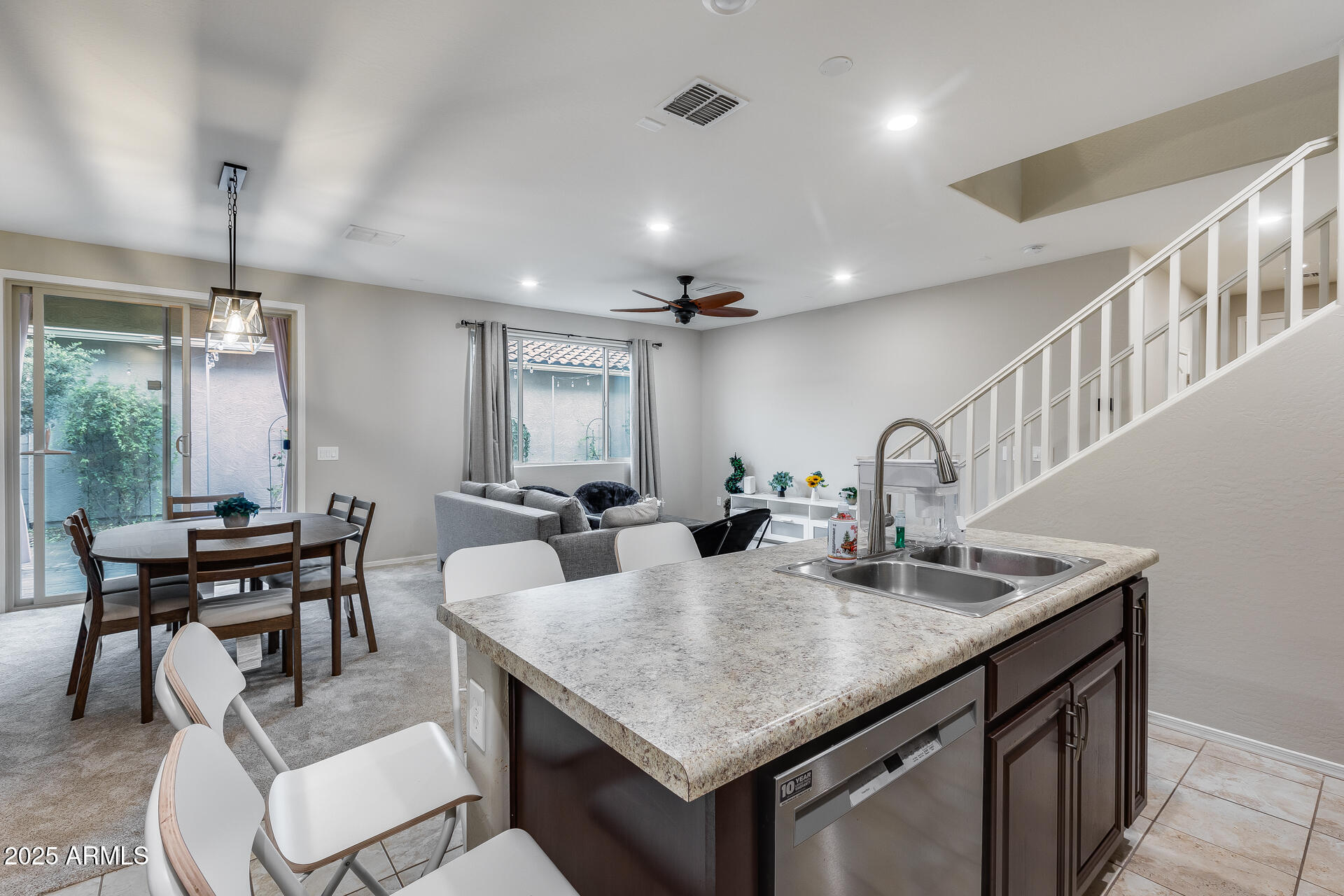 6853 East Posada Circle Mesa, AZ 85212 - Photo 17 of 45 a kitchen with granite countertop a table chairs stove and kitchen view