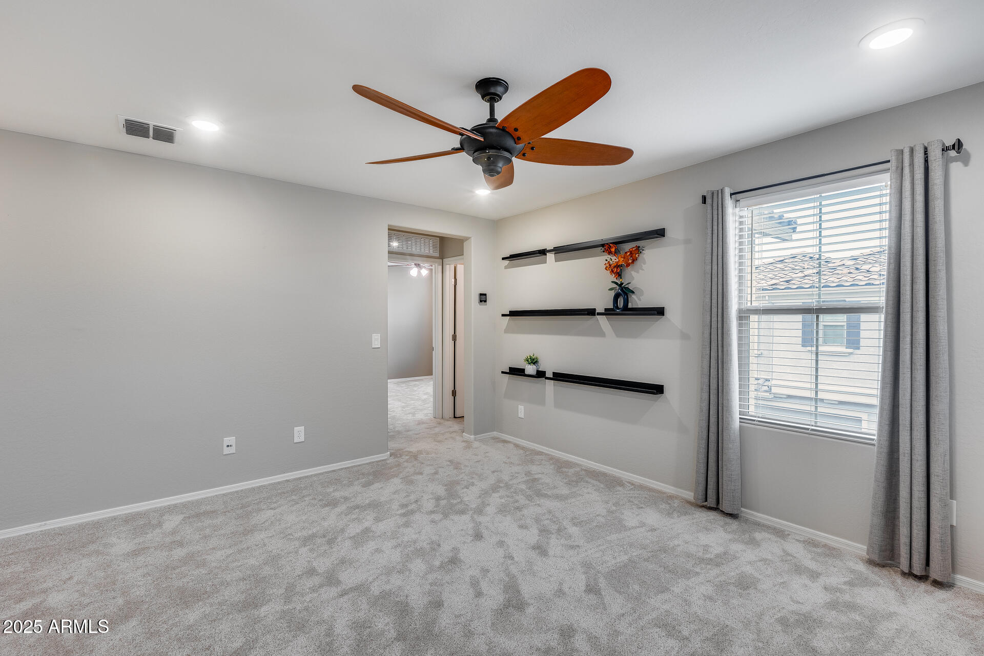 6853 East Posada Circle Mesa, AZ 85212 - Photo 20 of 45 an empty room with windows and ceiling fan