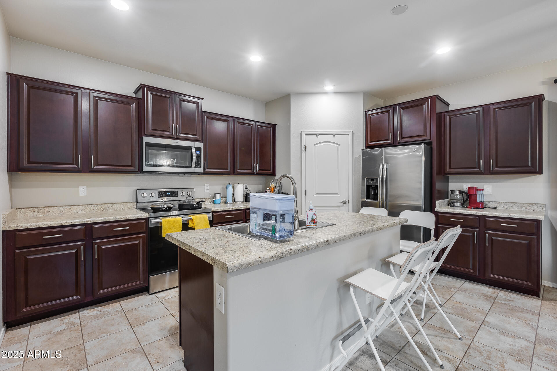 6853 East Posada Circle Mesa, AZ 85212 - Photo 2 of 45 a kitchen with stainless steel appliances granite countertop a stove top oven a sink dishwasher a dining table and chairs