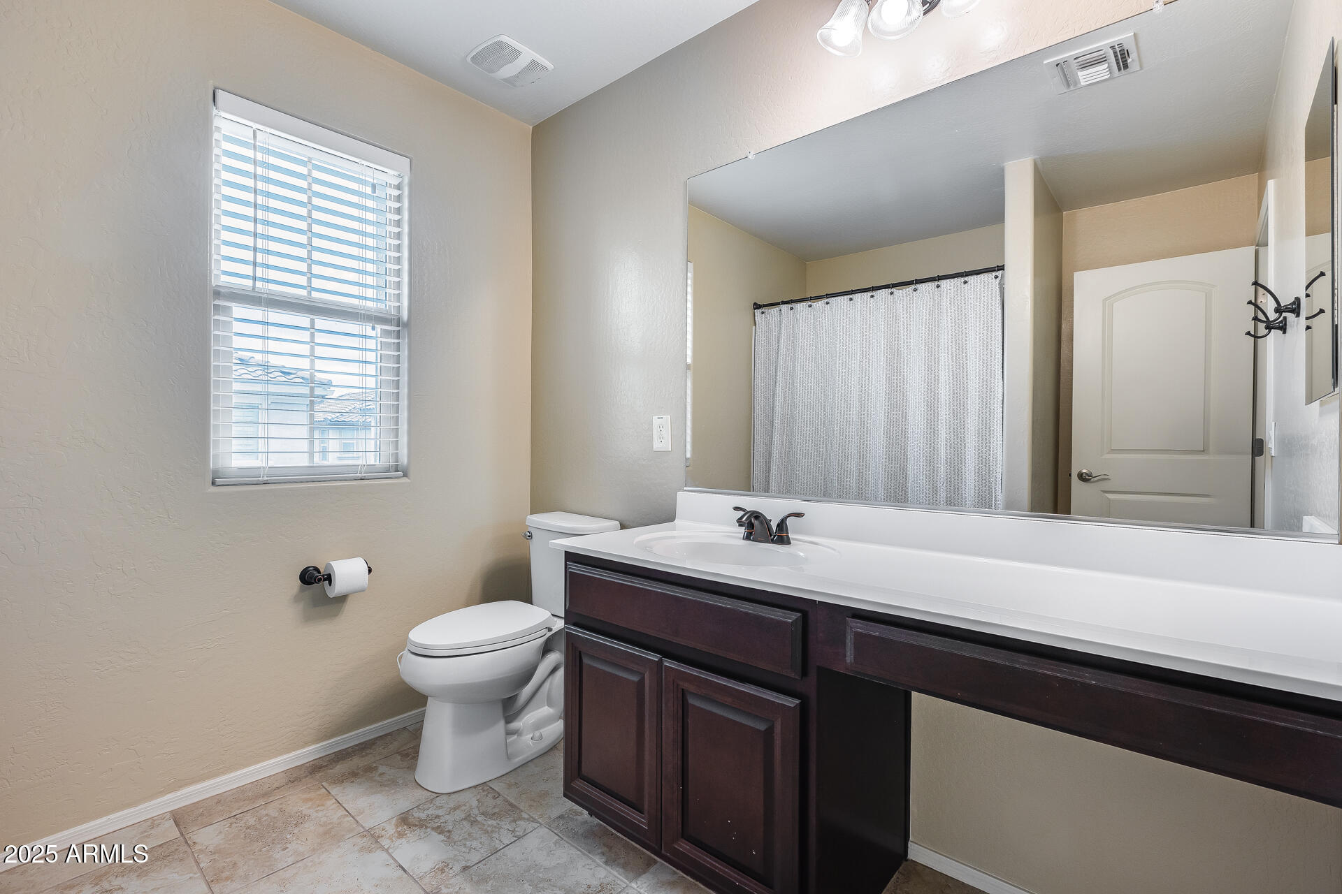 6853 East Posada Circle Mesa, AZ 85212 - Photo 32 of 45 a bathroom with a toilet sink and mirror