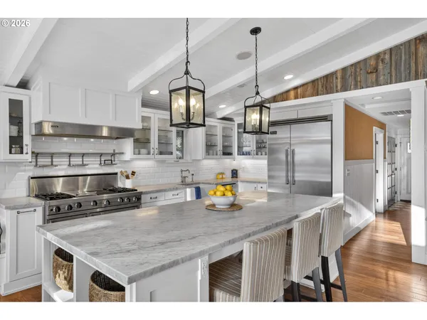 a kitchen with stainless steel appliances granite countertop a sink a refrigerator and wooden floor