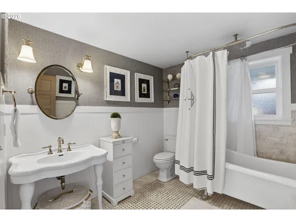 a bathroom with a sink toilet a mirror and shower