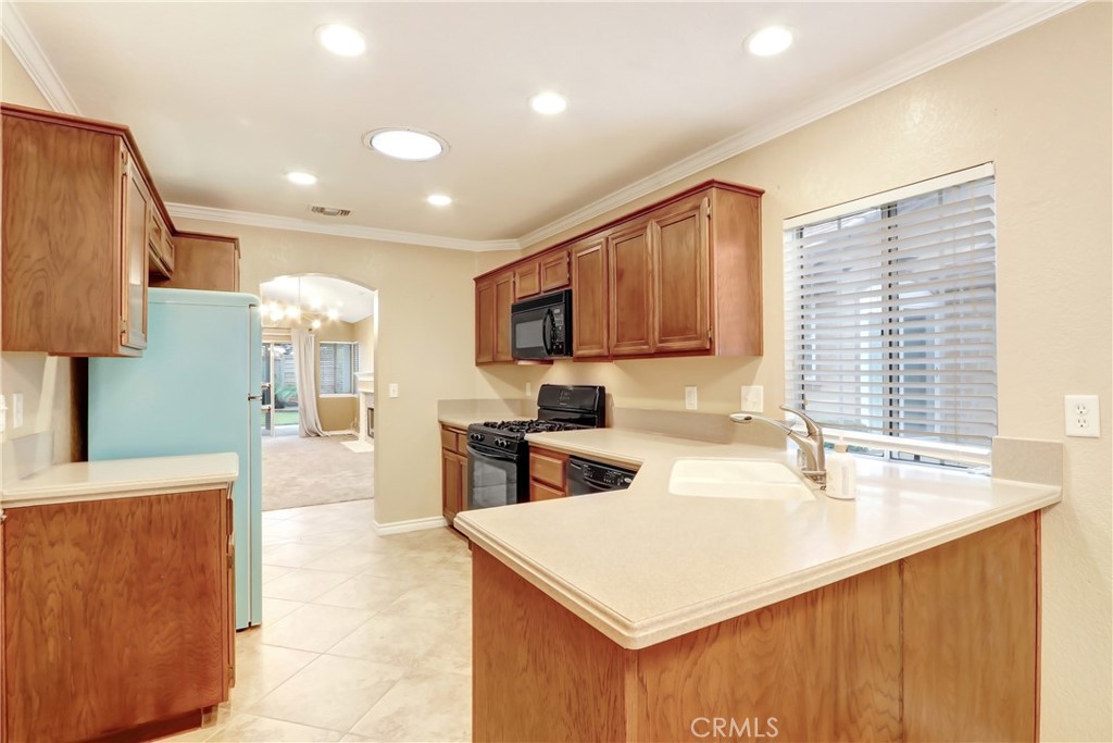 7622 Belpine Place Rancho Cucamonga, CA 91730 - Photo 7 of 15 a kitchen with a sink a stove a refrigerator and a microwave