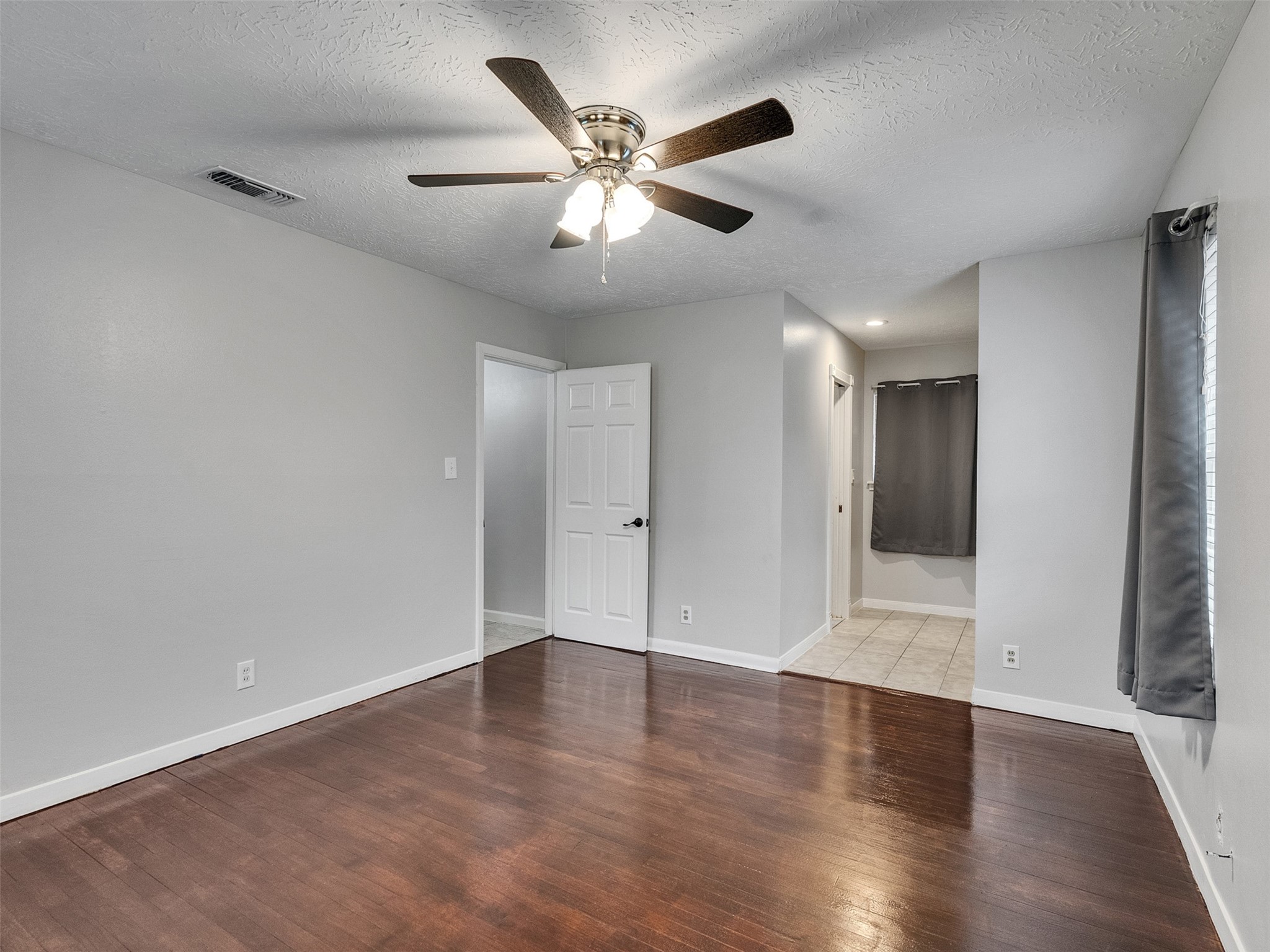 1630 Hollow Hook Road Houston, TX 77080 - Photo 18 of 22 an empty room with wooden floor and ceiling fan