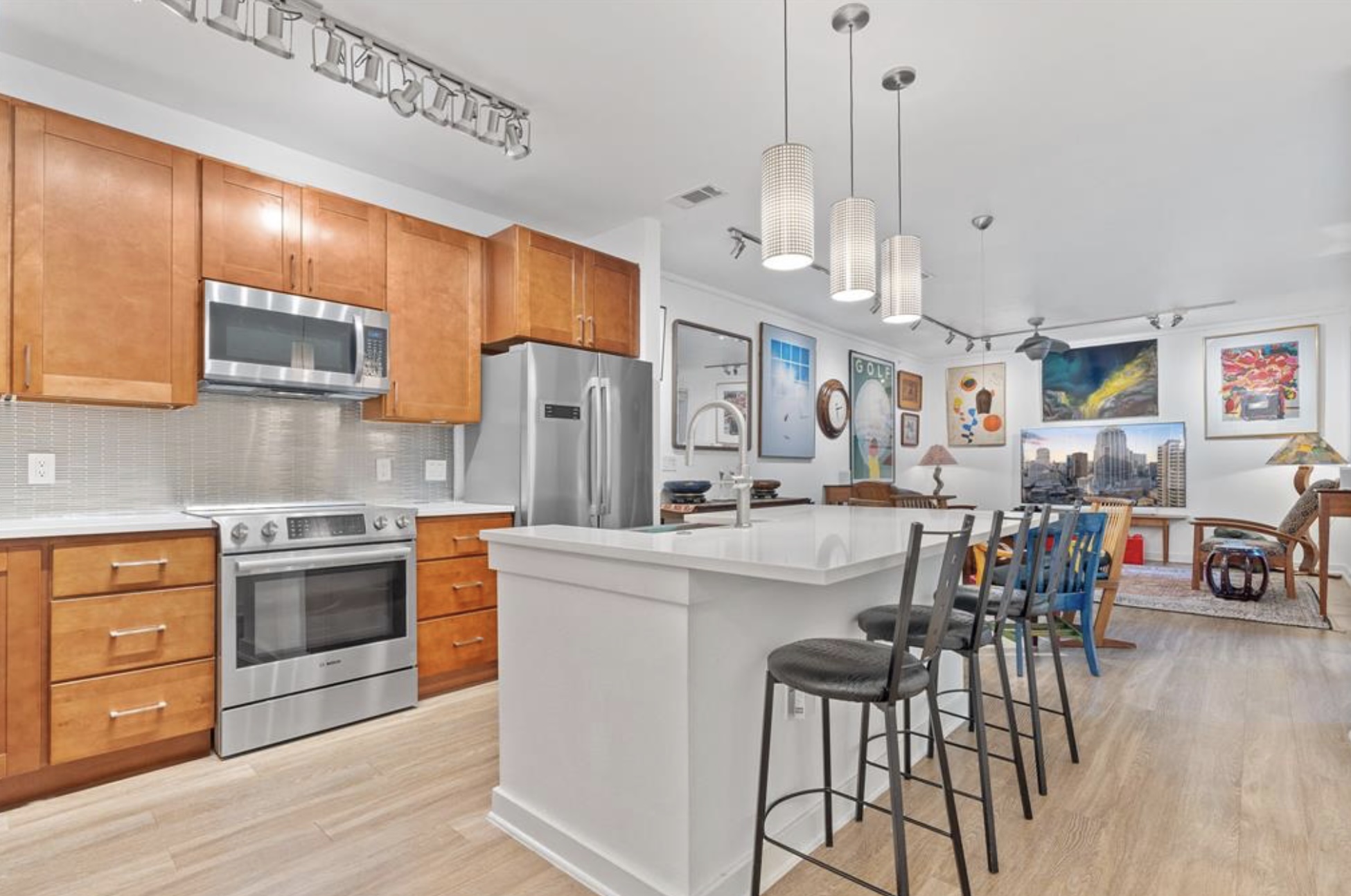 1900 Barton Springs Road, Unit 3031 Austin, TX 78704 - Photo 2 of 37 a kitchen with stainless steel appliances kitchen island granite countertop a stove a sink a refrigerator and white cabinets with wooden floor