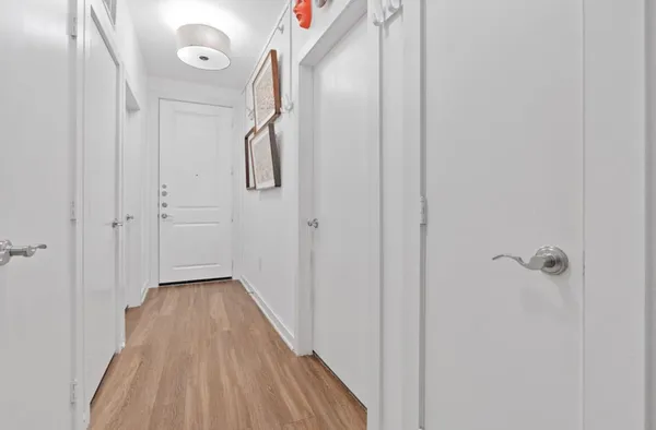 a view of a hallway with wooden floor and staircase