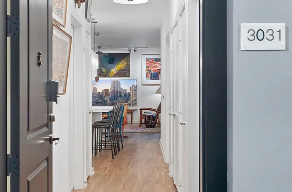 a view of a hallway with wooden floor and dining room