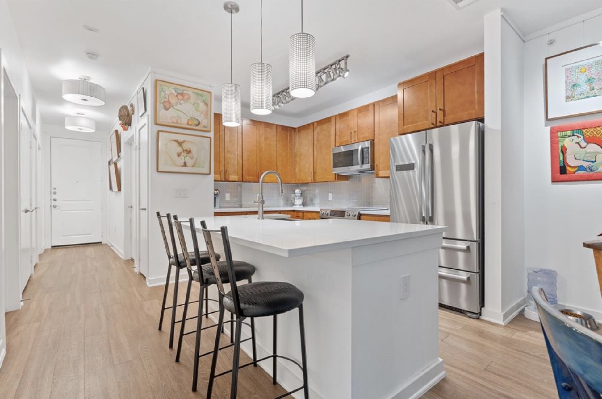 1900 Barton Springs Road, Unit 3031 Austin, TX 78704 - Photo 3 of 37 a kitchen with stainless steel appliances kitchen island granite countertop a refrigerator a sink a stove a dining table and chairs with wooden floor