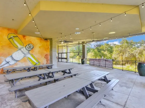 a view of a patio with chairs and umbrellas