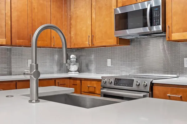 a kitchen with stainless steel appliances granite countertop a sink and a microwave