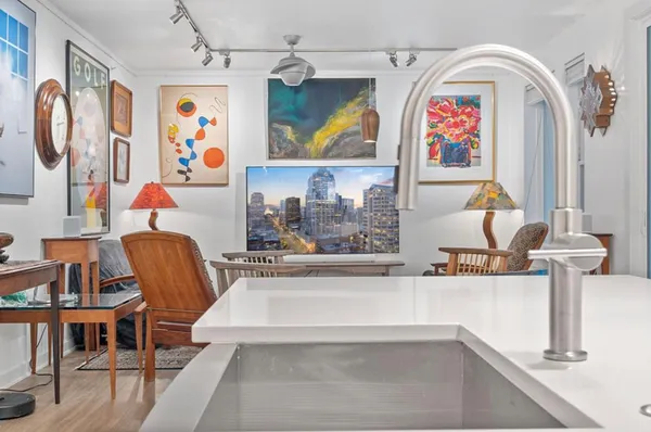 a living room with furniture and paintings on the wall