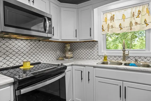 a kitchen with a sink stove and microwave